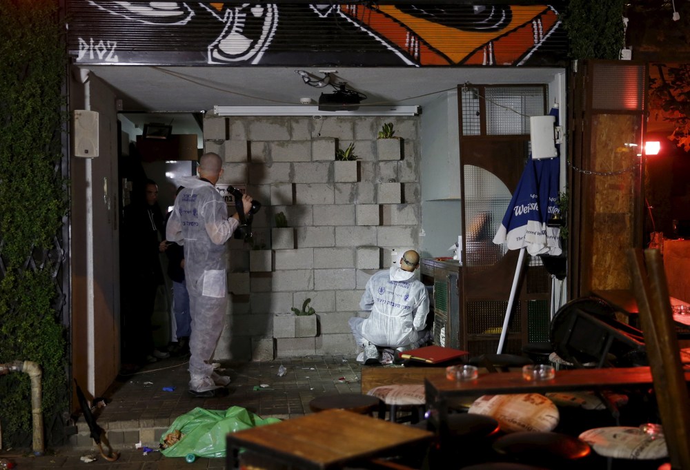 Israeli forensic policemen work at the scene of a shooting incident in Tel Aviv, Israel, Jan. 1, 2016. (Photo by Baz Ratner/Reuters)
