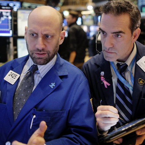 Specialist trader Meric Greenbaum gives a price quote to trader Greg Rowe on the floor of the New York Stock Exchange, Jan. 13, 2016. (Photo by Brendan McDermid/Reuters)