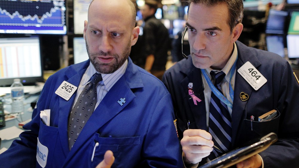 Specialist trader Meric Greenbaum gives a price quote to trader Greg Rowe on the floor of the New York Stock Exchange, Jan. 13, 2016. (Photo by Brendan McDermid/Reuters)