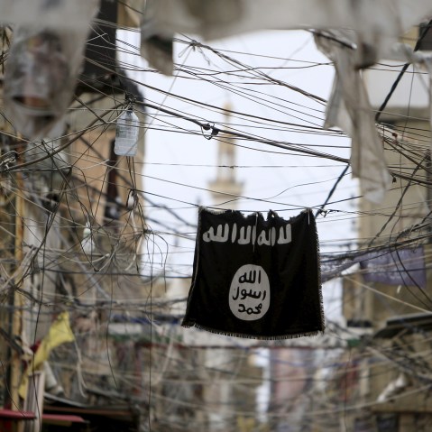 An Islamic State flag hangs amid electric wires over a street in Ain al-Hilweh Palestinian refugee camp, near the port-city of Sidon, southern Lebanon, Jan. 19, 2016. (Photo by Ali Hashisho/Reuters)