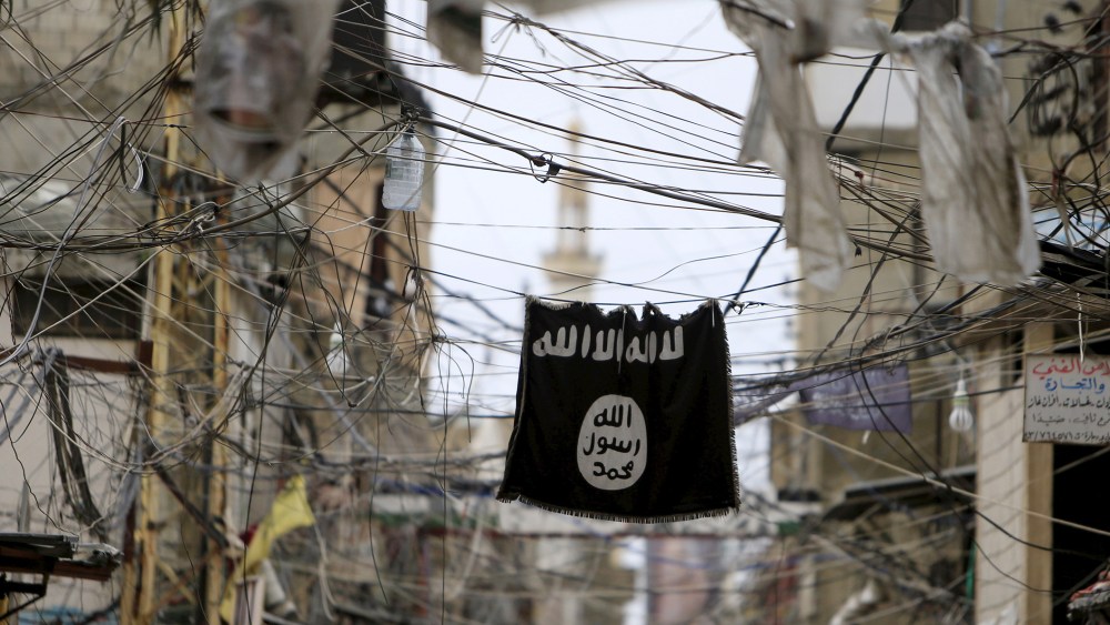 An Islamic State flag hangs amid electric wires over a street in Ain al-Hilweh Palestinian refugee camp, near the port-city of Sidon, southern Lebanon, Jan. 19, 2016. (Photo by Ali Hashisho/Reuters)