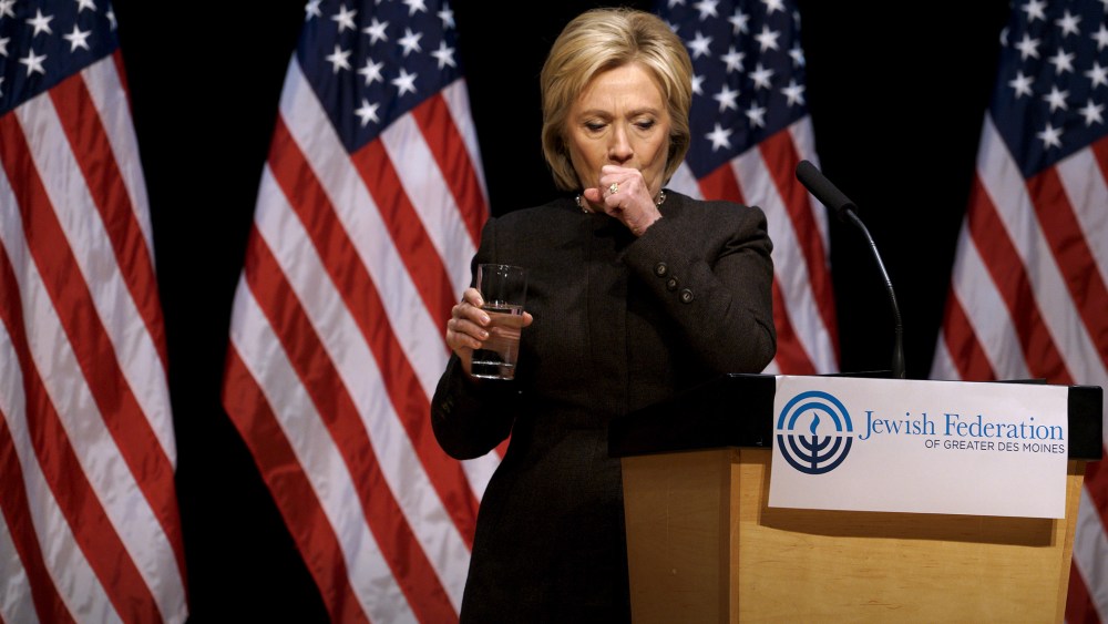Democratic presidential candidate Hillary Clinton holds up a glass of water as she struggles to contain a coughing fit at the Jewish Federation of Greater Des Moines, Iowa, Jan. 25, 2016. (Photo by Rick Wilking/Reuters)