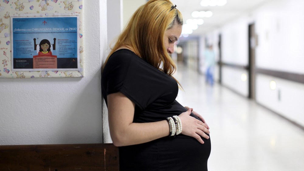 Jannelissa Santana, who is 37 weeks pregnant, leans on a wall, next to a flyer explaining how to prevent Zika, Dengue and Chikungunya viruses at a public hospital in San Juan, Puerto Rico, Feb. 3, 2016. (Photo by Alvin Baez/Reuters)