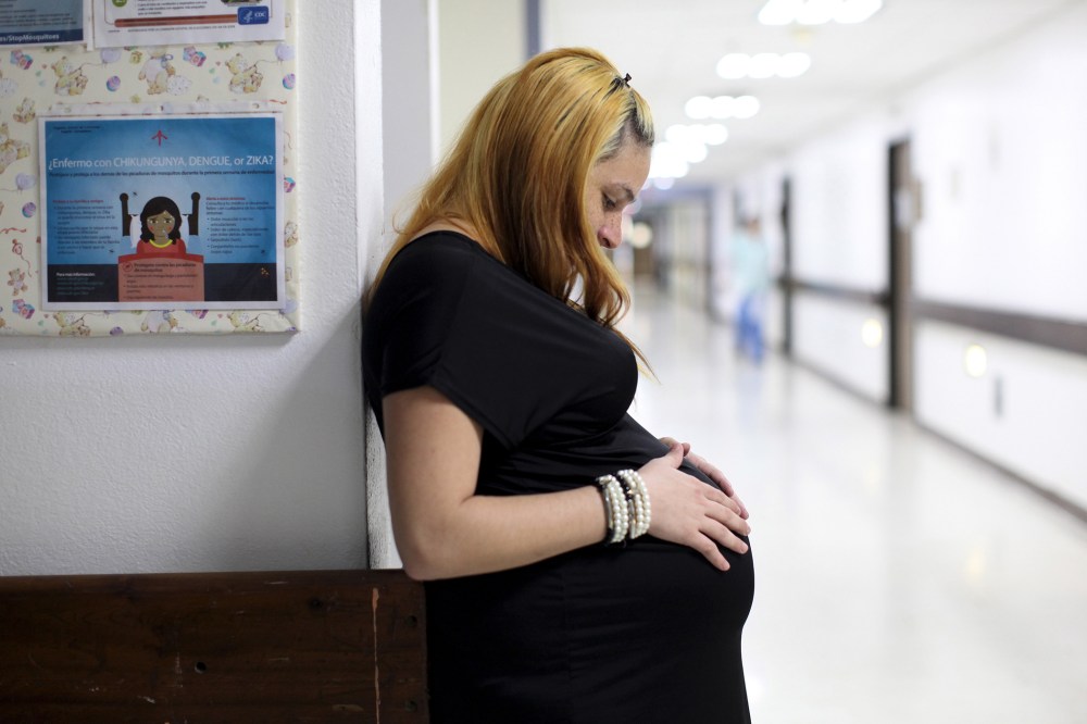 Jannelissa Santana, who is 37 weeks pregnant, leans on a wall, next to a flyer explaining how to prevent Zika, Dengue and Chikungunya viruses at a public hospital in San Juan, Puerto Rico, Feb. 3, 2016. (Photo by Alvin Baez/Reuters)