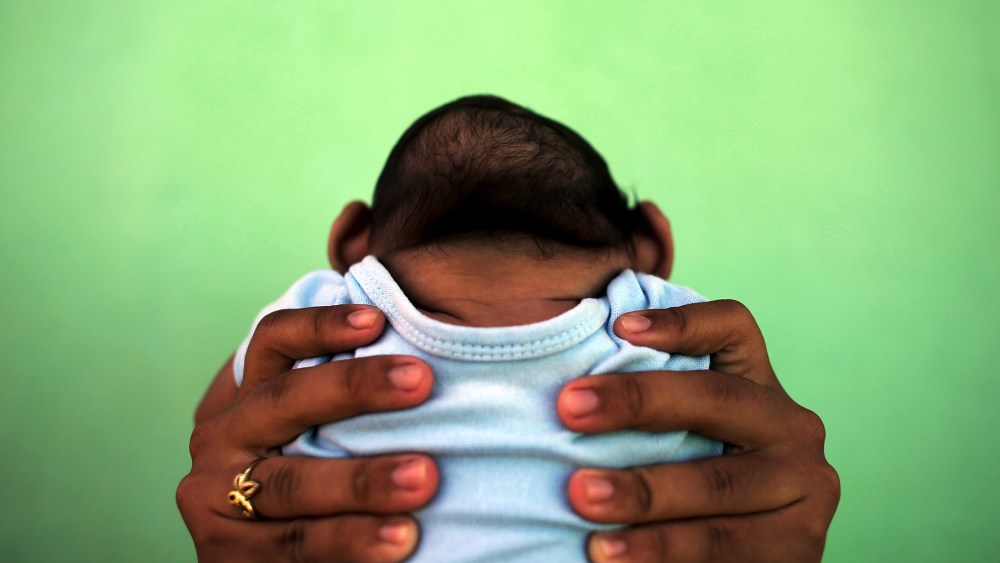 Jackeline, 26, holds her son who is 4-months old and born with microcephaly, in front of their house in Olinda, near Recife, Brazil, Feb. 11, 2016. (Photo by Nacho Doce/Reuters)