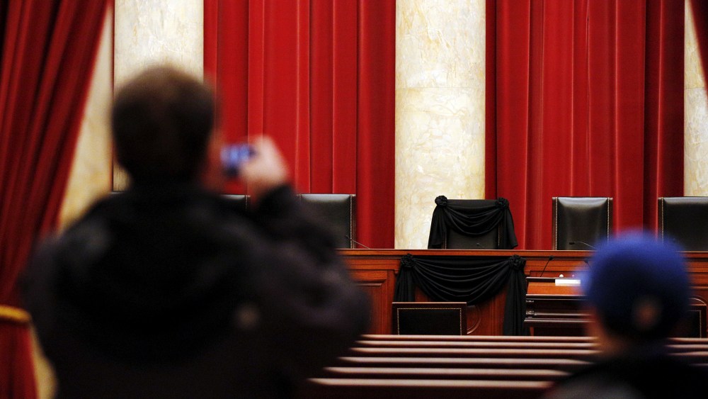 A visitor takes a picture of the bench of late Supreme Court Justice Antonin Scalia, draped with black wool crepe, inside the Supreme Court in Washington, Feb. 16, 2016. (Photo by Carlos Barria/Reuters)