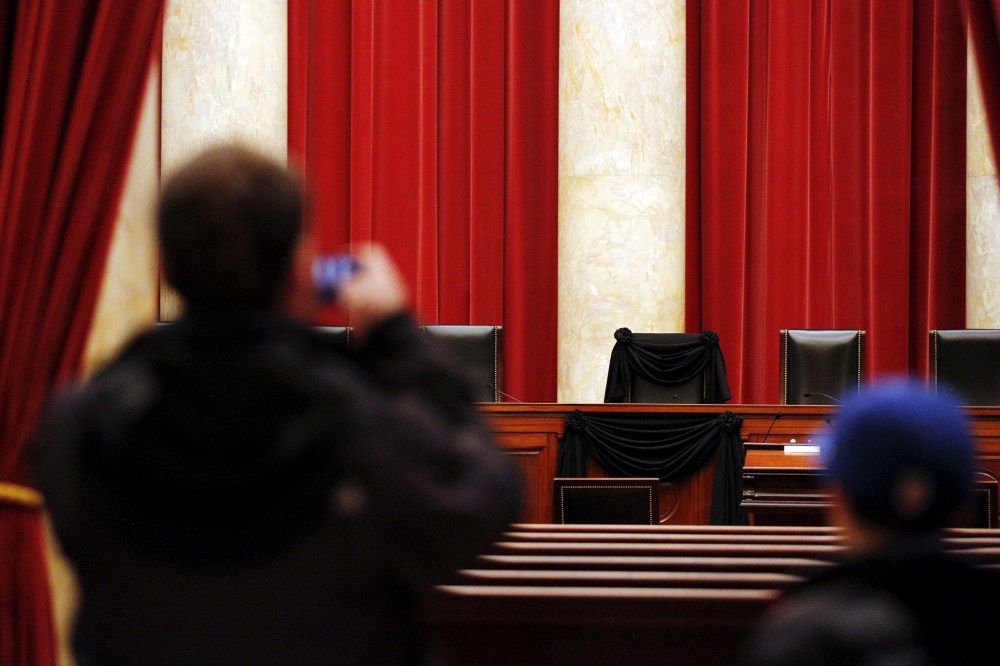 A visitor takes a picture of the bench of late Supreme Court Justice Antonin Scalia, draped with black wool crepe, inside the Supreme Court in Washington, Feb. 16, 2016. (Photo by Carlos Barria/Reuters)