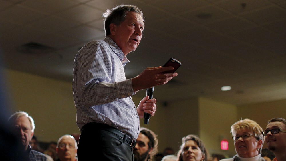 Republican presidential candidate and Ohio Governor John Kasich holds up a phone at a campaign town hall meeting in Worcester, Mass., Feb. 20, 2016. (Photo by Brian Snyder/Reuters)