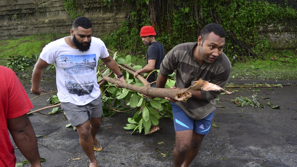Fijian men clear a road of a fallen tree in Fiji's capital Suva after Cyclone Winston swept across Viti Levu Island, Feb. 21, 2016. (Photo by Taniela Qalilawa/Reuters)