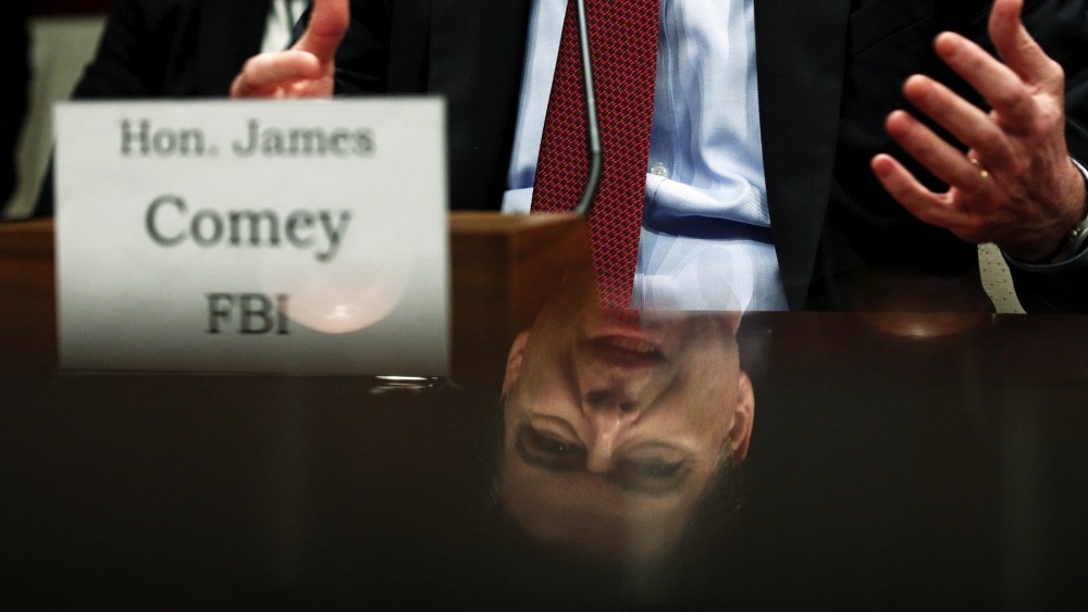 FBI Director James Comey is seen in a reflection as he testifies in a House Appropriations hearing on "World Wide Threats" on Capitol Hill in Washington, Feb. 25, 2016. (Photo by Kevin Lamarque/Reuters)
