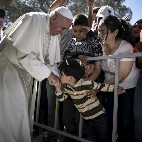A boy shakes the hand of Pope Francis as he greets migrants and refugees at Moria refugee camp near the port of Mytilene, on the Greek island of Lesbos, April 16, 2016. (Photo by Andrea Bonetti/Greek PM Press Office/Handout/Reuters)