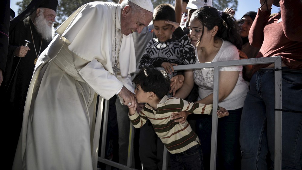 A boy shakes the hand of Pope Francis as he greets migrants and refugees at Moria refugee camp near the port of Mytilene, on the Greek island of Lesbos, April 16, 2016. (Photo by Andrea Bonetti/Greek PM Press Office/Handout/Reuters)