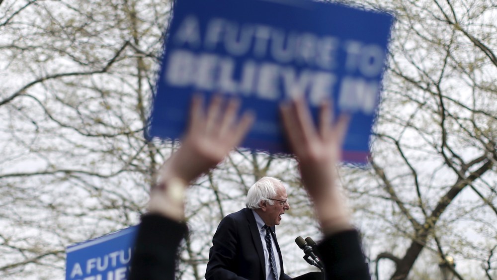 U.S. Democratic presidential candidate Bernie Sanders is seen between the arms a supporter waving a sign as he speaks at a campaign rally in Hartford, Conn. on April 25, 2016. (Photo by Mike Segar/Reuters)