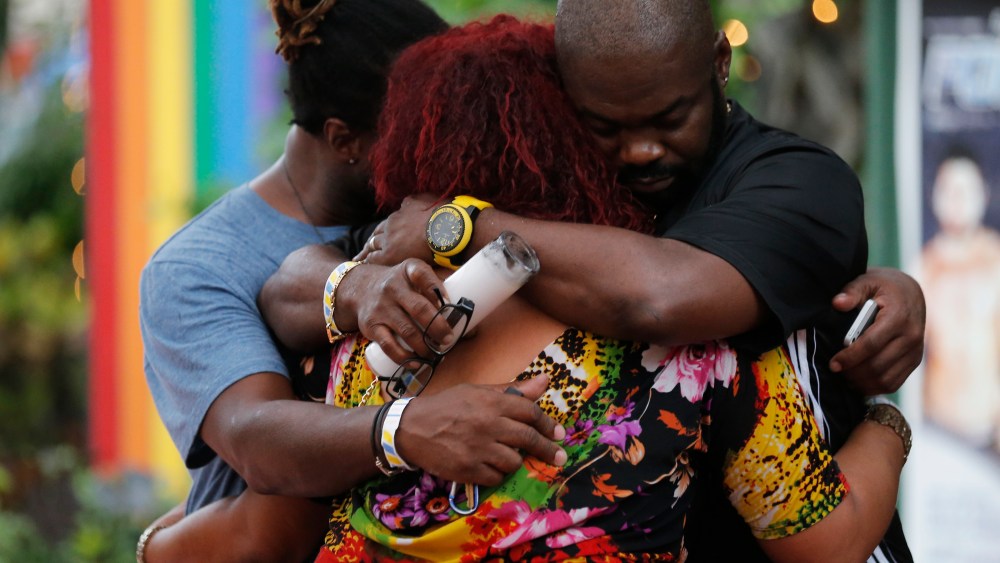 People embrace following a candlelight vigil at the Parliament House Resort after an early morning shooting attack at a gay nightclub in Orlando on June 12, 2016.