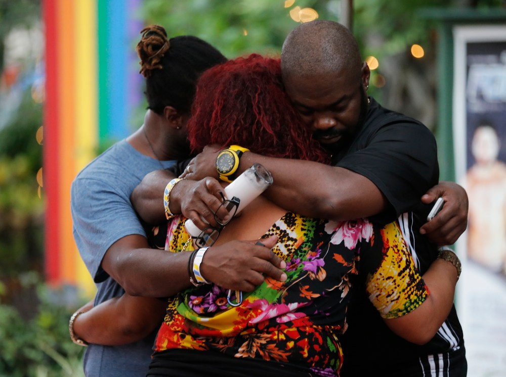 People embrace following a candlelight vigil at the Parliament House Resort after an early morning shooting attack at a gay nightclub in Orlando on June 12, 2016.