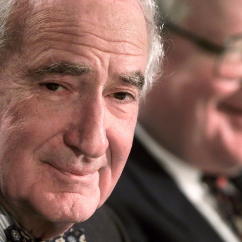 Comcast Chairman Ralph Roberts (L) smiles during a press conference. (Photo by Peter Morgan/Reuters)
