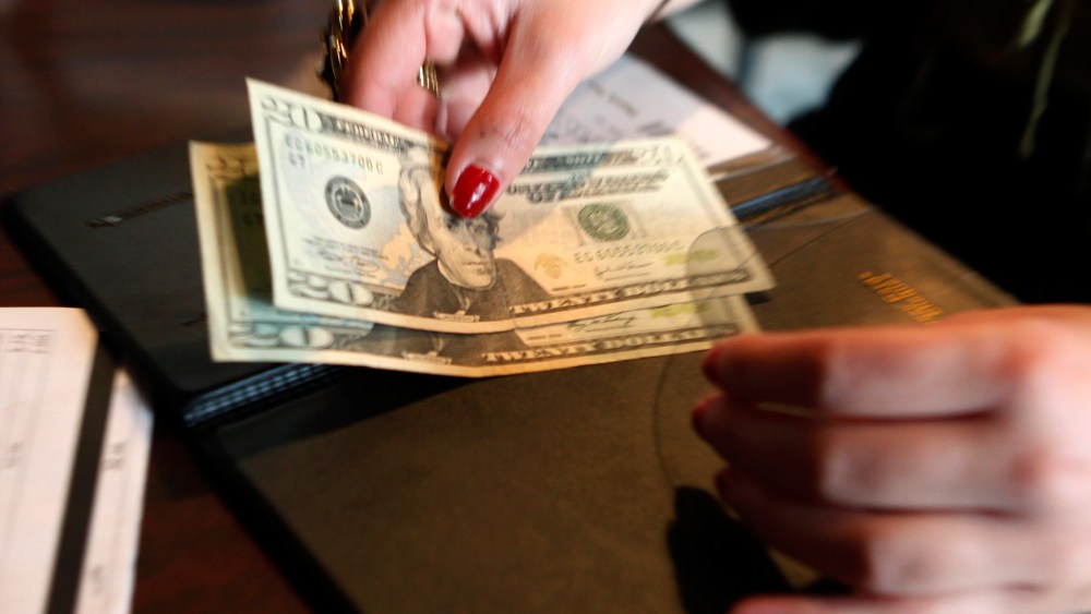 A customer pays her lunch bill at the Other Side Cafe in Boston