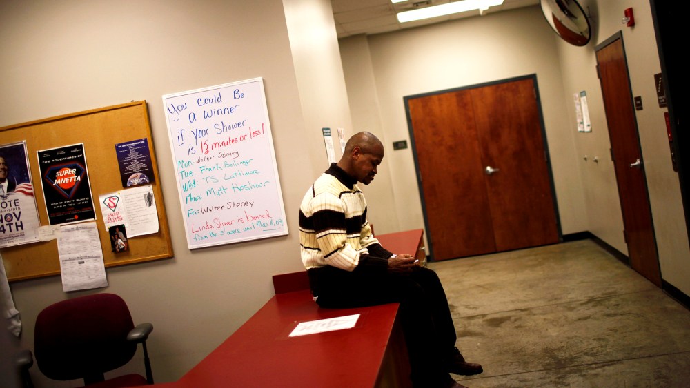 A man sits on a table at the Urban Ministry soup kitchen in Charlotte, N.C.