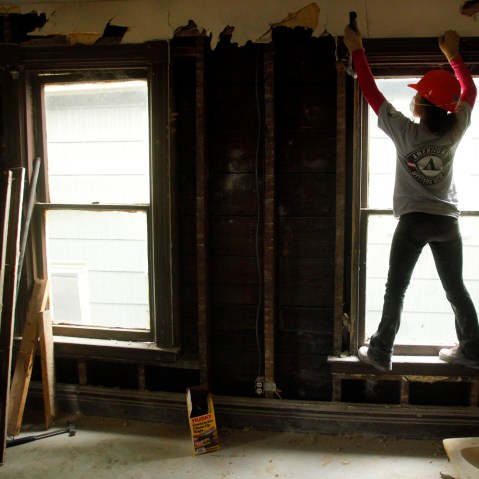 Americorps worker Yoshi Batcho helps gut a house being renovated into affordable housing by PUSH, a non-profit organization working to rebuild the West Side of Buffalo, New York, Nov. 19, 2009.
