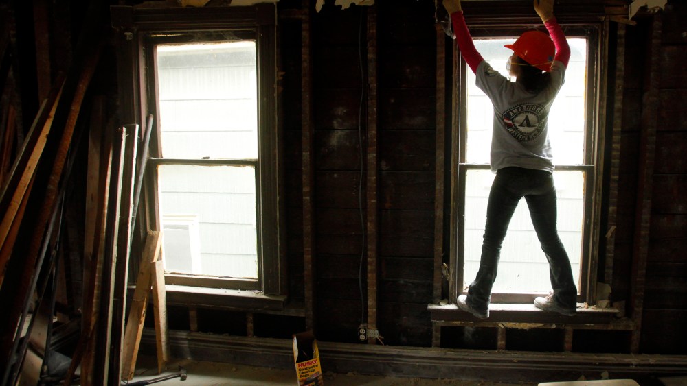 Americorps worker Yoshi Batcho helps gut a house being renovated into affordable housing by PUSH, a non-profit organization working to rebuild the West Side of Buffalo, New York, Nov. 19, 2009.