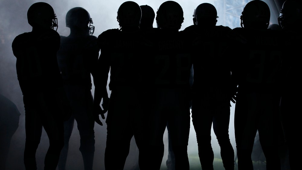 NFL players wait to be introduced to the crowd before playing in a game. (Photo by Mike Blake/Reuters)