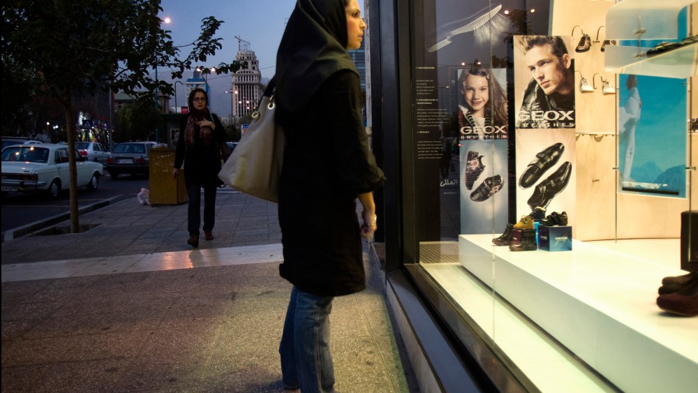An Iranian woman looks in the window of a Geox store in northern Tehran