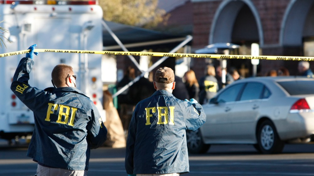 FBI agents process a shooting scene in Tucson, Ariz., Jan. 11, 2011. (Photo by Rick Wilking/Reuters)