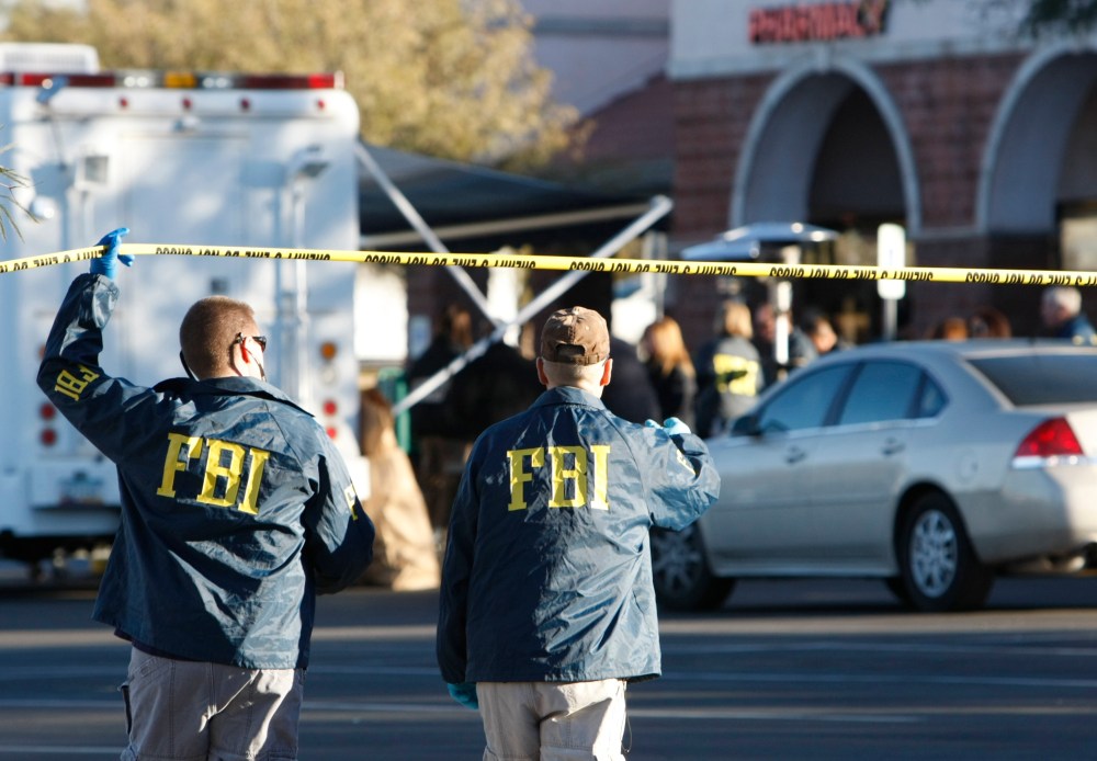FBI agents process a shooting scene in Tucson, Ariz., Jan. 11, 2011. (Photo by Rick Wilking/Reuters)