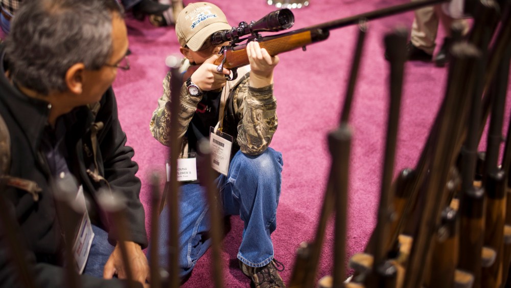 A child checks out a hunting rifle at the Safari Club International Convention in Reno, Nevada, January 29, 2011.