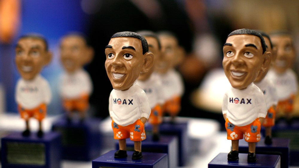 Figures of President Obama with the word "Hoax" are on display at the CPAC in Washington