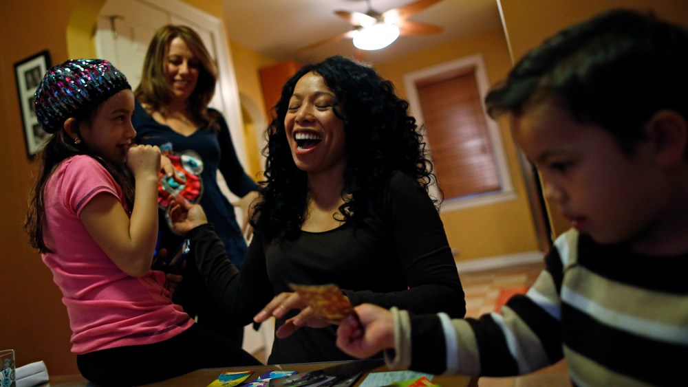 Mercedes Santos shares a laugh with her partner, Theresa Volpe, while playing cards with their kids at home in Chicago, Illinois, December 22, 2012.