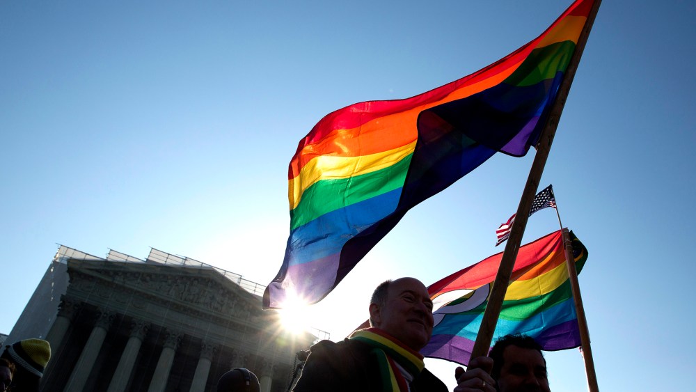 Supporters of gay marriage hold rainbow-colored flags as they rally in front of the Supreme Court in Washington March 27, 2013.