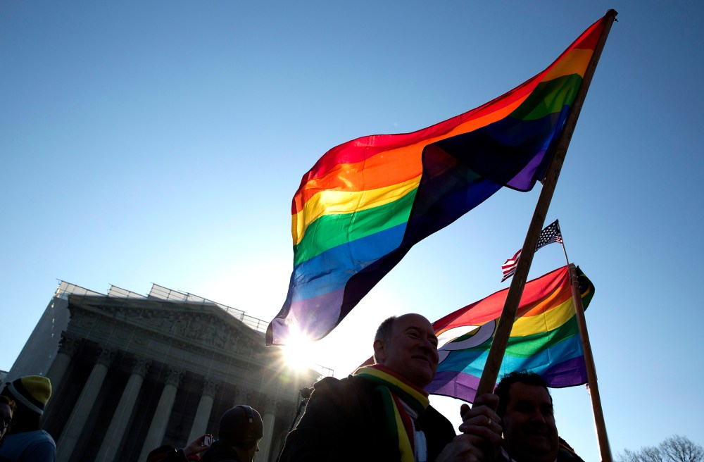Supporters of gay marriage hold rainbow-colored flags as they rally in front of the Supreme Court in Washington March 27, 2013.