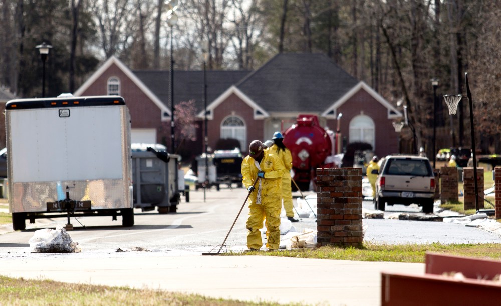 Emergency crews work to clean up an oil spill in front of evacuated homes on Starlite Road in Mayflower
