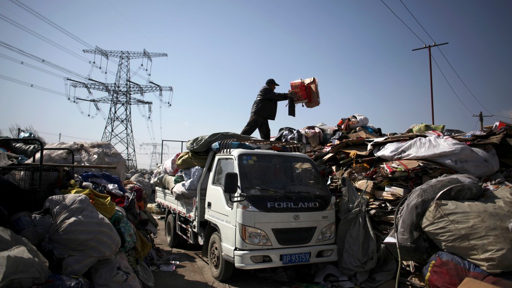 A worker unloads waste at the Xiejiacun waste collection market in the Changping district of Beijing  on April 8, 2013.