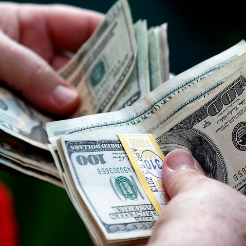 A man counts his money. (Photo by Phil Noble/Reuters)