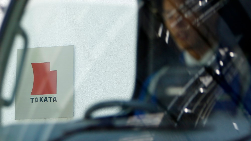 Logo of Takata Corp is seen through a car window outside the company's headquarter building in Tokyo
