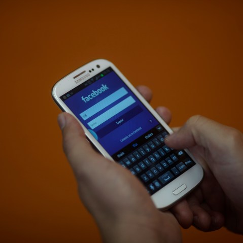 A smartphone user logs into his Facebook account in Rio de Janeiro on April 15, 2013.