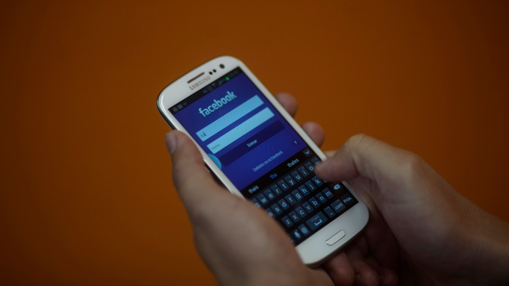 A smartphone user logs into his Facebook account in Rio de Janeiro on April 15, 2013.