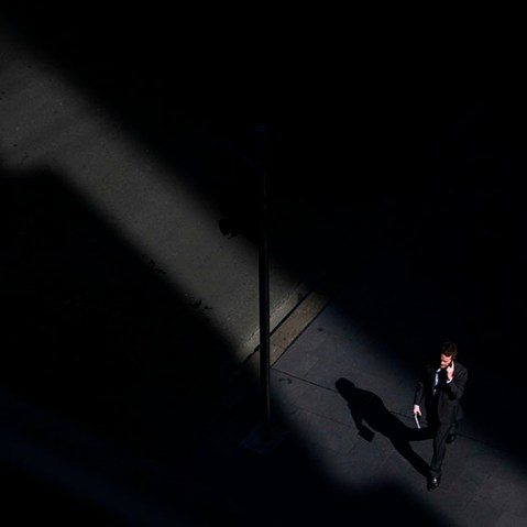 A man talks on his mobile phone as he walks through a shaft of sunlight along a street in Sydney's central business district (CBD) April 18, 2013. (Photo by David Gray/Reuters)