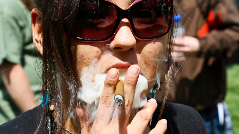 A woman smokes a blunt at the 4/20 marijuana holiday in Civic Center Park in downtown Denver April 20, 2013.