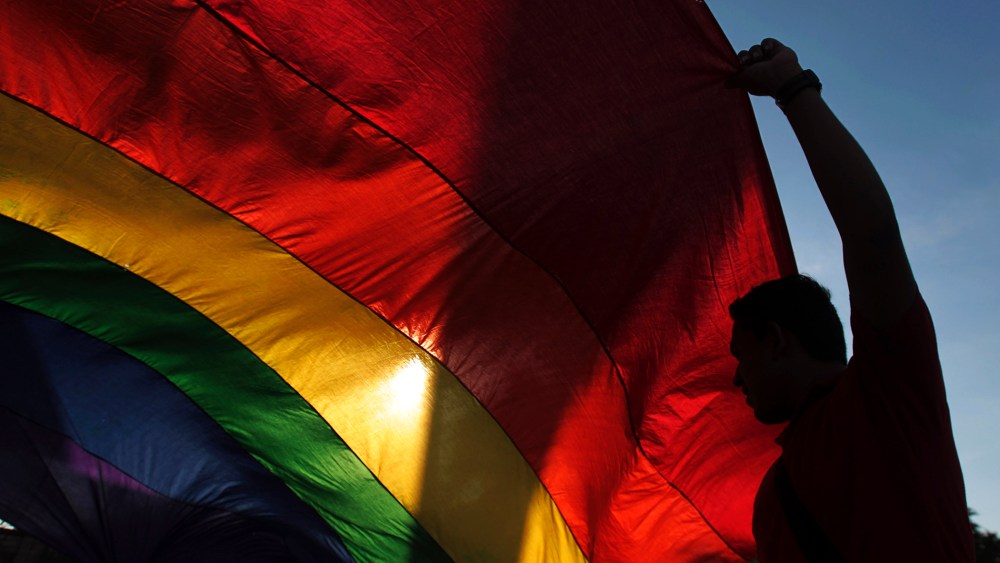 A gay rights activist holds a rainbow flag during a rally to mark the International Day Against Homophobia in Managua