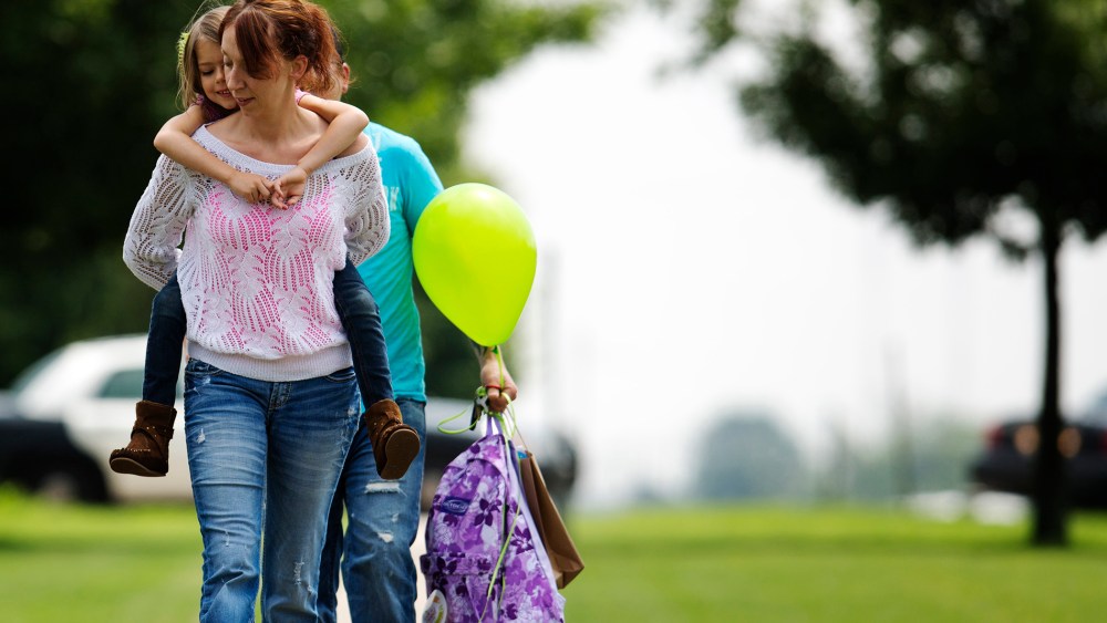 Jayme Sheppard carries her daughter as she departs for school in Oklahoma City, Oklahoma, May 23, 2013.
