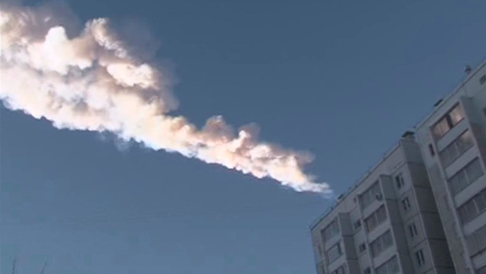 The trail of a falling object is seen above a residential apartment block in the Urals city of Chelyabinsk, in this still image taken from video shot on February 15, 2013. A powerful blast rocked the Russian region of the Urals early on Friday with...