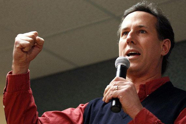 Rick Santorum pumps his fist at a rally wearing a sweater vest.