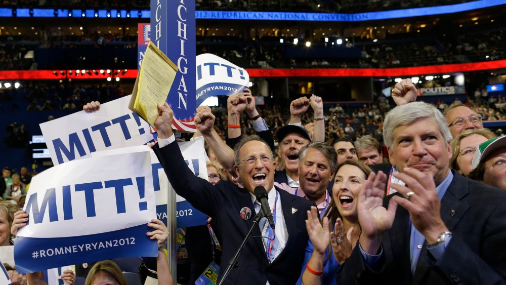 Michigan delegate Scott Romney, center with a note pad, and the rest of Michigan delegates react at the Republican National Convention in Tampa, Fla., on Tuesday, Aug. 28, 2012. At right is Michigan Gov. Rick Snyder. (AP Photo/Charles Dharapak)