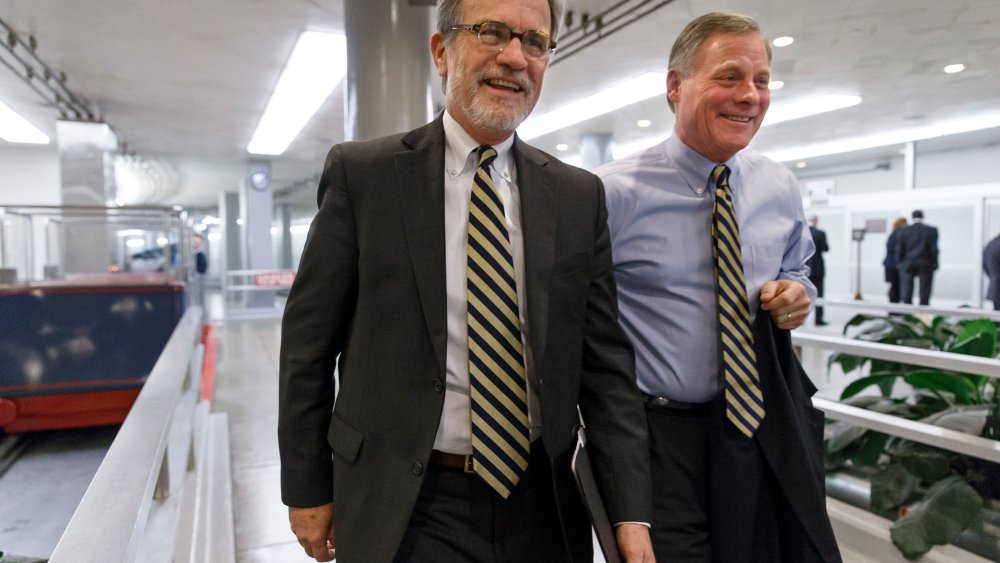 Sen. Tom Coburn, R-Okla., left, walks with Sen. Richard Burr, R-N.C., at the Capitol in Washington, Thursday, Dec. 19, 2013.