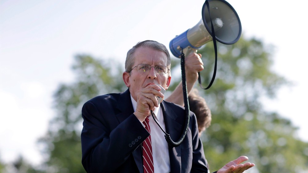 In this Monday, Aug. 4, 2014 photograph, Jeff Bell uses a bullhorn to address a gathering in Cherry Hill, N.J.