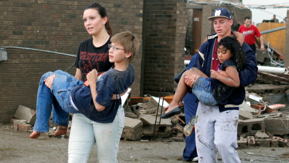 Teachers carry children away from Briarwood Elementary school after a tornado destroyed the school in south Oklahoma City, Okla, Monday, May 20, 2013. Near SW 149th and Hudson. (AP Photo/ The Oklahoman,  Paul Hellstern)