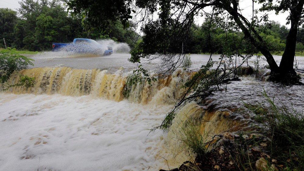 A motorist passes through a low-water crossing near New Braunfels, Texas, June 2, 2016. (Photo by Eric Gay/AP)